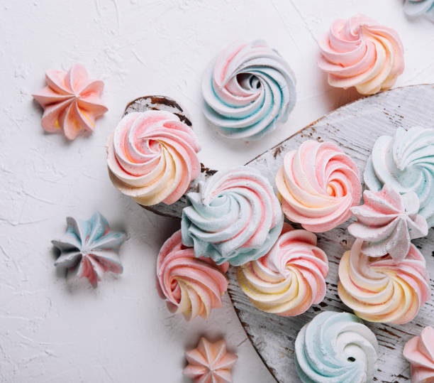 istock Multicolored meringue on wooden tray top view 1472531783