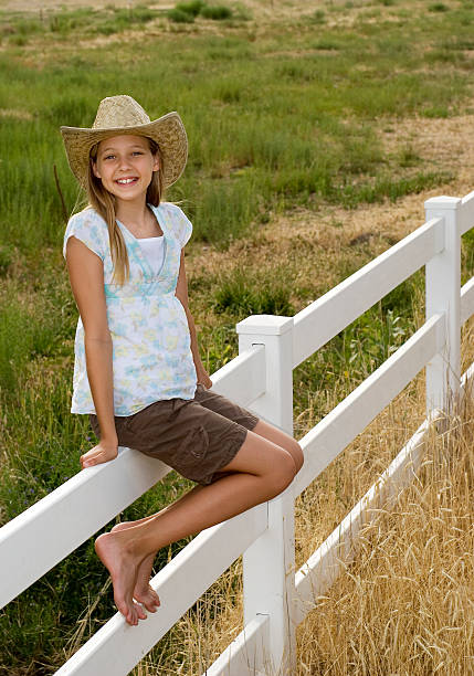 Close up shot of the little cowgirl on a fence
