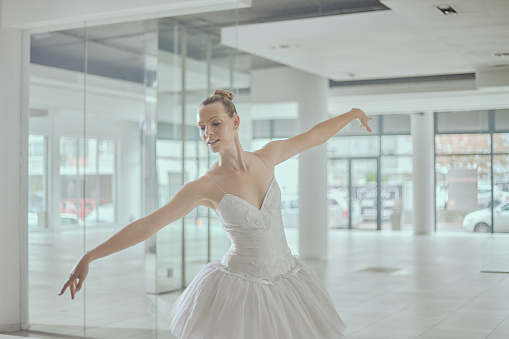 Dance academy, ballet and ballerina in studio for performance, dancing practice and training. Theatre mockup, creative hobby and happy girl in elegant pose for stage routine, rehearsal and balance