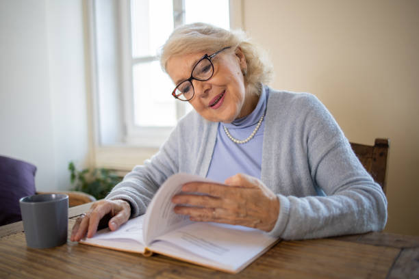 istock Woman reading book at home 1472538227