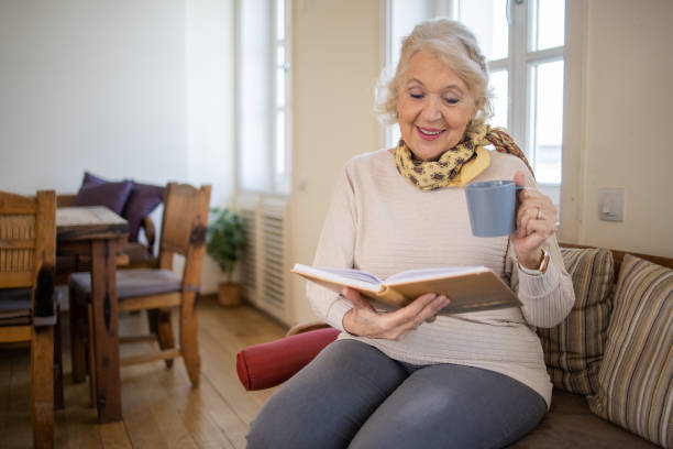 istock Woman reading book at home 1472538252