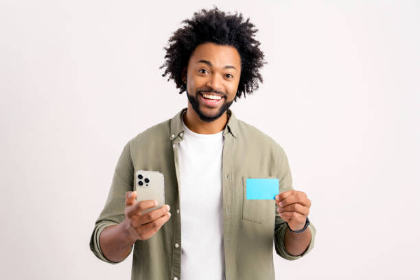 istock Cheerful middle eastern guy is using smartphone and credit card for shopping online. Happy man is ordering food online, male paying for long-awaited purchase on the mobile phone, isolated 1472540021