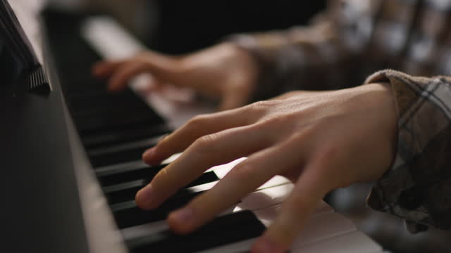 Teenage boy practicing piano at home