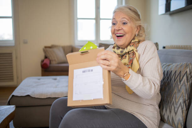 istock Senior woman is holding cardboard box 1472543451