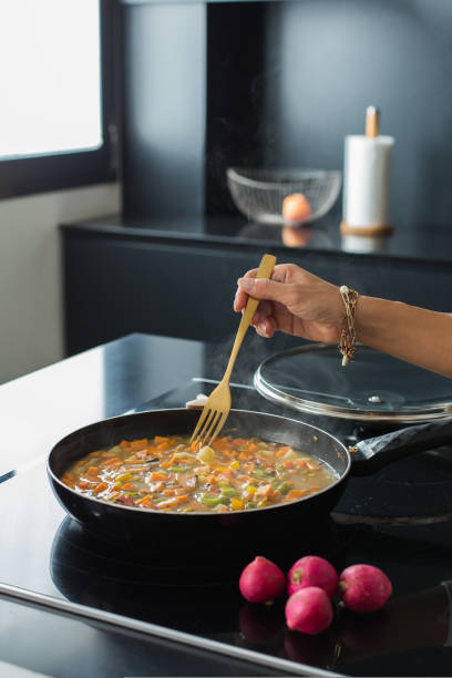 istock Woman hands adding ingredients in a vegetable stew 1472543763