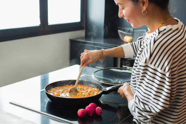 istock Woman hands adding ingredients in a vegetable stew 1472544843