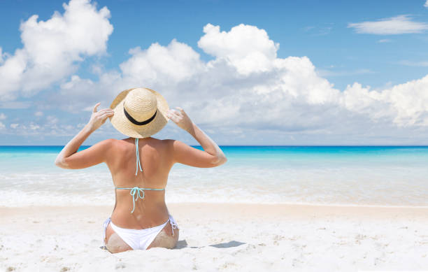 istock Woman sitting on the sea beach 1472544949