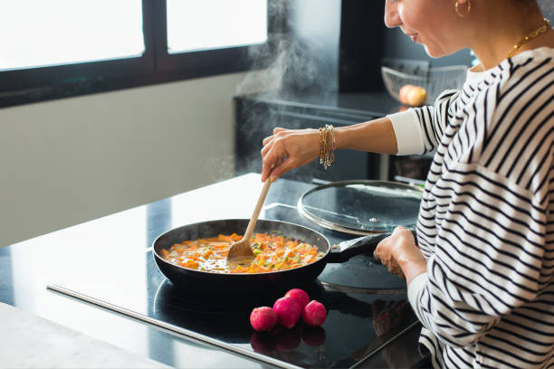 istock Woman hands adding ingredients in a vegetable stew 1472545014