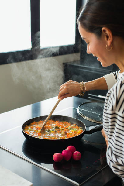 istock Woman hands adding ingredients in a vegetable stew 1472545186