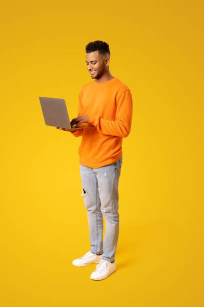 Smart and concentrated Indian guy using laptop isolated stock photo
