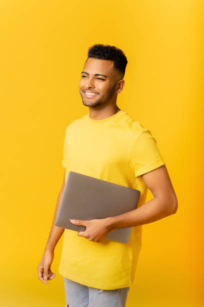 istock Handsome cheerful smiling Indian man holding laptop, smiling 1472547782