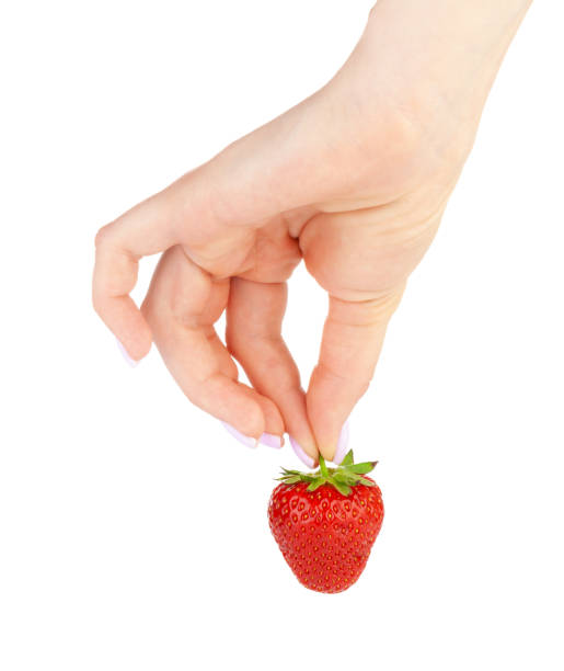 istock hand holding a strawberry isolated on white background 1472548631