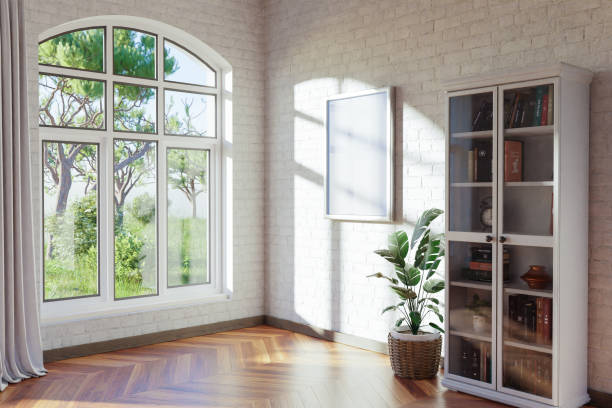 istock empty canvas poster mock up hanging on a wall; empty living room interior; bright daylight shining through a large window; home decoration desing; 3D Illustration 1472551024