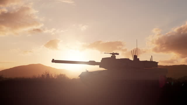 Military tank moving forward in the field against the sunset sky