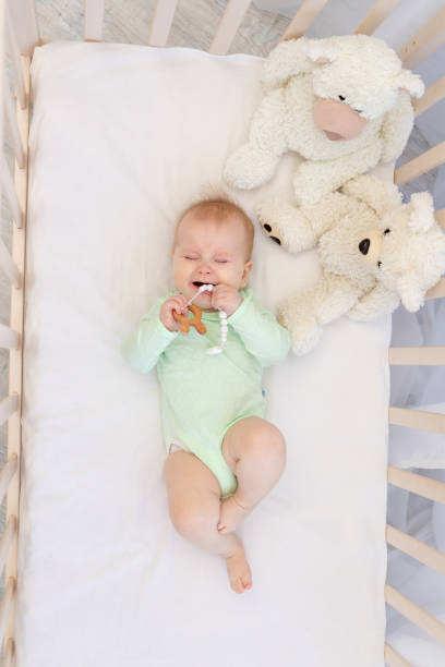 istock a crying baby in a crib with a teether in the bedroom 1472554513