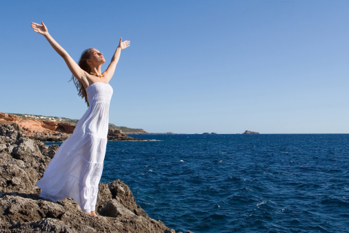 woman arms raised with joy on vacation