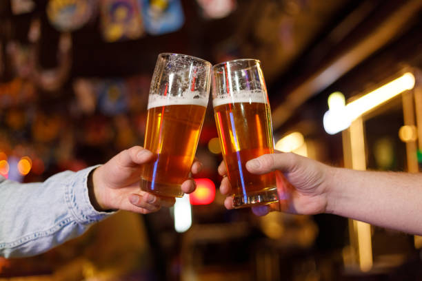 istock People drinking and toasting beer on pub and bar background. St. Patrick's Day 1472555903