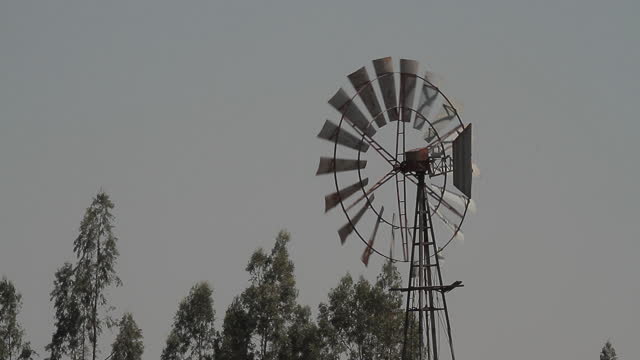 Old-fashioned windmill with a tail fin spinning on wind