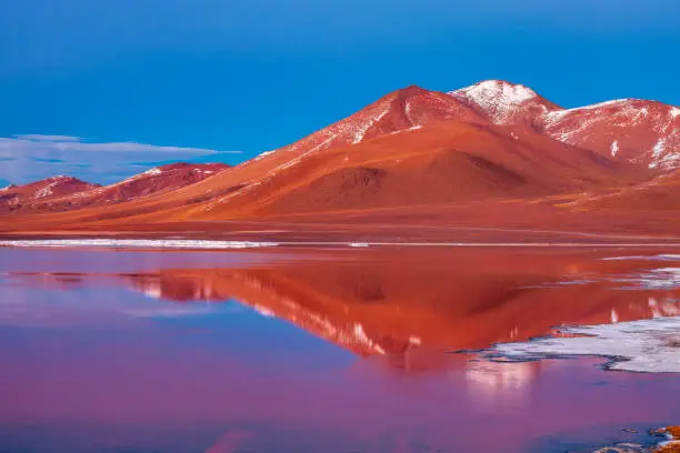 Sunrise over Laguna Colorada, Bolivian Altiplano. The Altiplano (Spanish for high plain), in west-central South America, where the Andes are at their widest, is the most extensive area of high plateau on earth outside of Tibet. Lake Titicaca is its best known geographical feature. The Altiplano is an area of inland drainage (endorheism) lying in the central Andes, occupying parts of Northern Chile and Argentina, Western Bolivia and Southern Peru. Its height averages about 3,750 meters (12,300 feet), slightly less than that of Tibet. Unlike the Tibetan Plateau, however, the Altiplano is dominated by massive active volcanoes of the Central Volcanic Zone to the west like Ampato (6288 m), Tutupaca (5816 m), Nevado Sajama (6542 m), Parinacota (6348 m), Guallatiri (6071 m), Cerro Paroma (5728 m), Cerro Uturuncu (6008 m) and Licancabur (5916 m), and the Cordillera Real in the north east with Illampu (6368 m), Huayna Potosi (6088 m), Ancohuma (6427 m) and Illimani (6438 m). The Atacama Desert, one of the driest areas on the whole planet, lies to the southwest of the Altiplano. In contrast, to the east lies the humid Amazon Rainforest.
