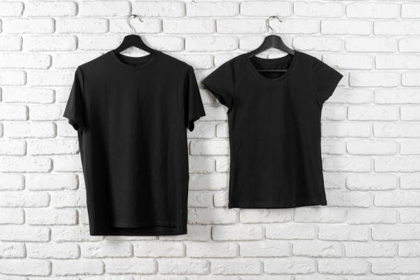 istock Black t-shirt hanging on a hanger against brick wall 1472556458