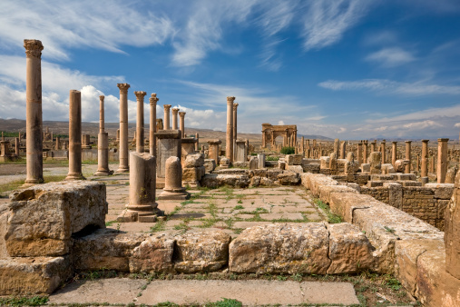 Algeria. Timgad (ancient Thamugadi or Thamugas). Row of Corinthian columns at the forum and colonnade along Decumanus Maximus street (on right) terminated Trajan's Arch. Please see my other images of Roman places in Tunisia and Libya