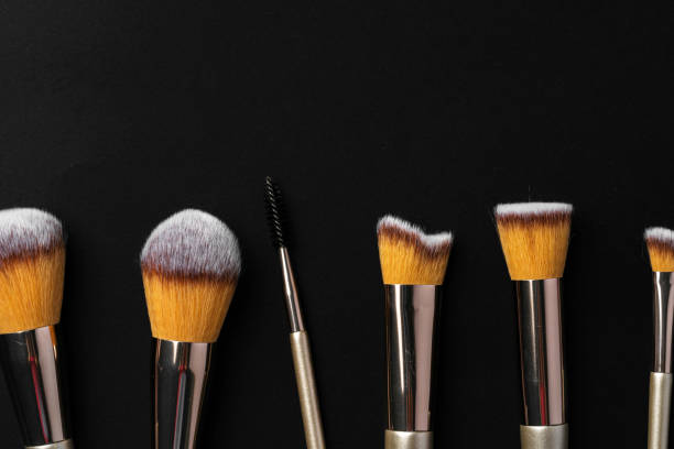 istock Collection of make up brushes on black background 1472561404