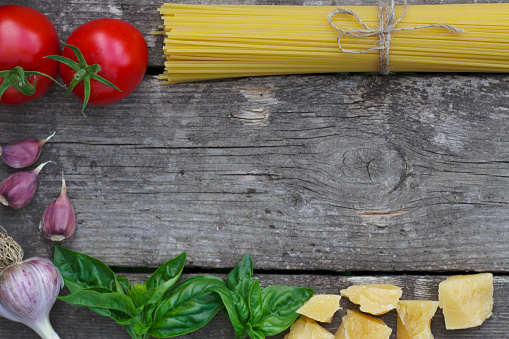 pasta and vegetables for cooking sause on the old wooden table with copy space