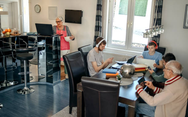 wielopokoleniowa rodzina wykorzystująca technologię bezprzewodową w domu - grandparent using computer laptop dining table zdjęcia i obrazy z banku zdjęć