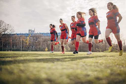 Group of women, female rugby team training together outdoors.