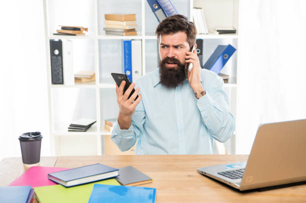 istock Worried lawyer talking on cellphone using smartphone at office desk, mobility 1472573055