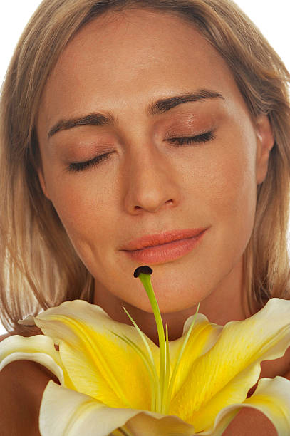 Kobieta cieszy się zapach z lily – zdjęcie