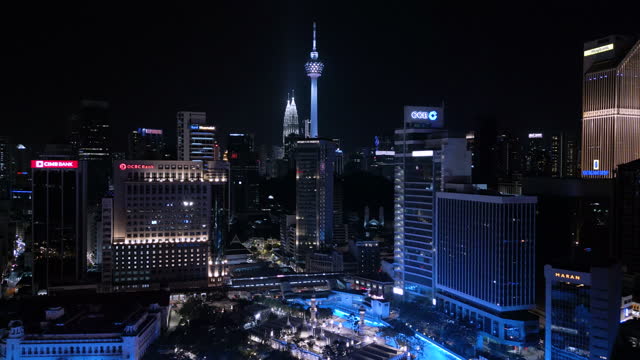 Aerial view of illuminated Masjid Jamek and skyscrapers at night in Kuala Lumpur
