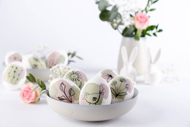 istock Bowl with modern creative trendy  hand painted easter egg in spring flowers on white background.  Homemade tradition Easter ideas. Greeting card 1472585729