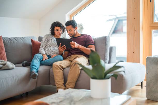 istock Modern Pregnant Couple Using Wireless Technology At Home 1472588012