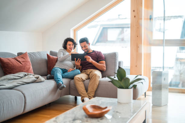 istock Multicultural Pregnant Couple Sitting On A Couch, Surfing The Net With A Digital Tablet 1472588015