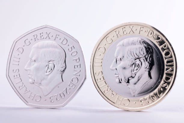 Haverfordwest, Wales - March 2, 2023: Studio shot of the first one pound coin and fifty pence coin issued depicting King Charles III. Produced by the British Royal Mint to commemorate his ascension to the throne, the obverse shows the king facing left and the reverse depicts an image from British history.