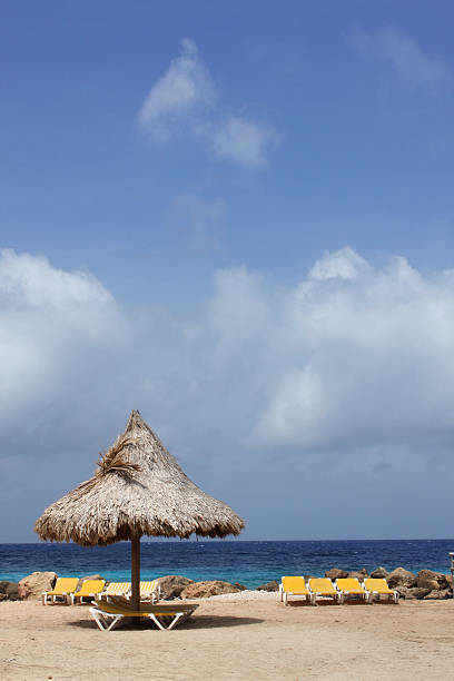 Caribbean beach umbrella and sun chairs. stock photo