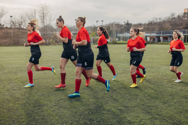 Group of women, female rugby team training together outdoors.