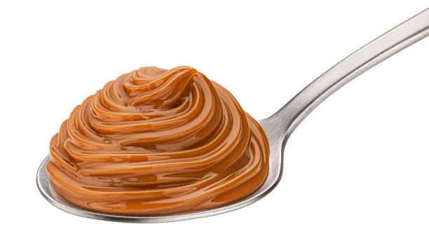 istock Melted caramel cream in spoon isolated on white background 1472605883