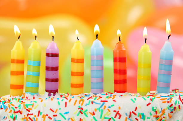 istock Multicolored birthday candles in a cake with sprinkles 147261317