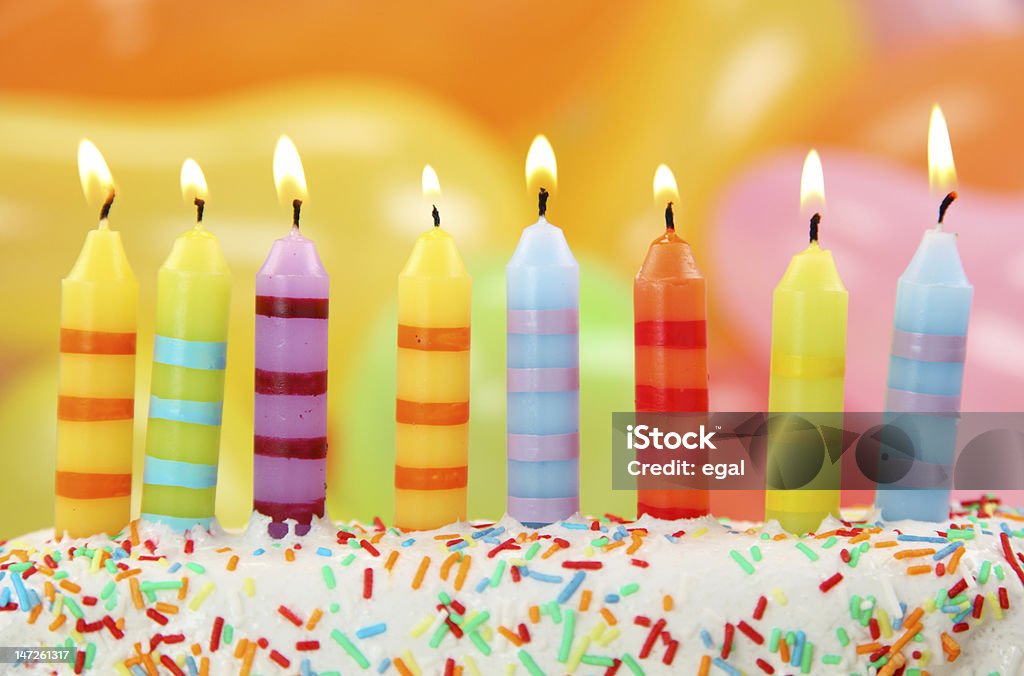 Multicolored birthday candles in a cake with sprinkles Birthday candles on colorful background Birthday Stock Photo