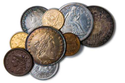 Close-up image of coins with a shallow depth of field.  Coins that were pulled out of savings account or inheritance because of economic hardship.  Variance of silver, cold, copper currency from different countries.