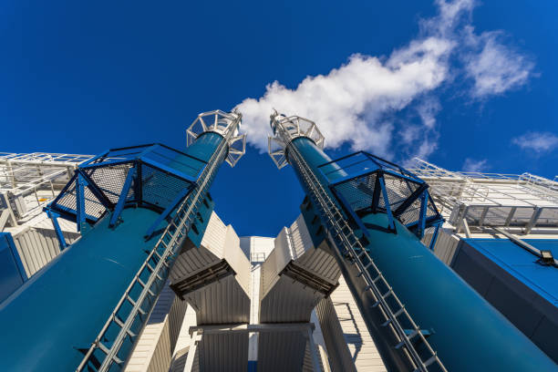 External view of the modern biomass power plant with smoking chimneys on the beautiful blue sky background