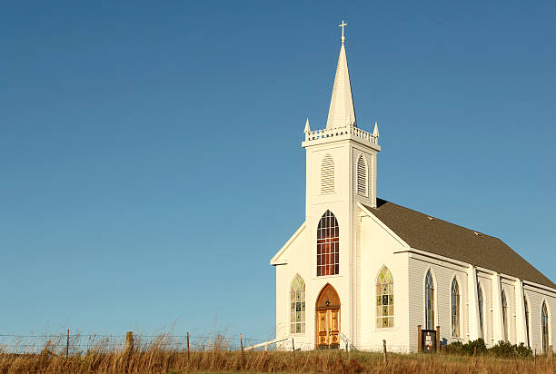 istock White country church over a meadow on a cloud-less sky 147261877