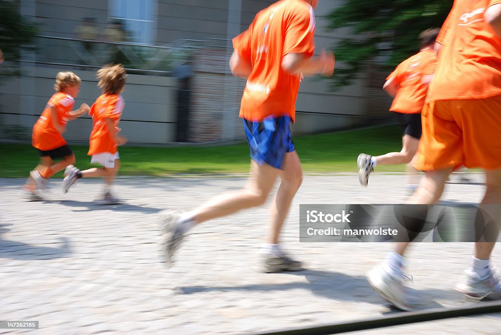 running people in orange shirts, motion blur Child Stock Photo