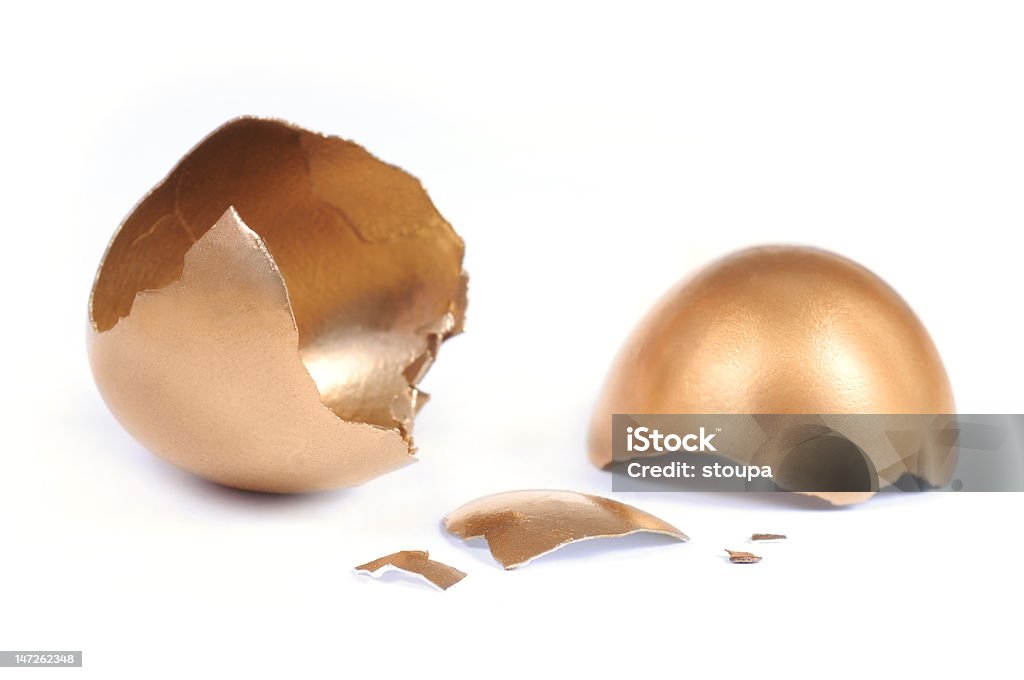 Cracked golden egg Cracked golden egg on white background. Animal Egg Stock Photo