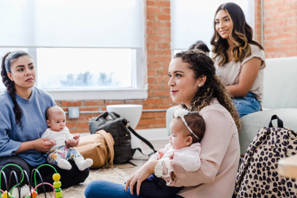 istock Young moms holding babies share in group therapy 1472625147