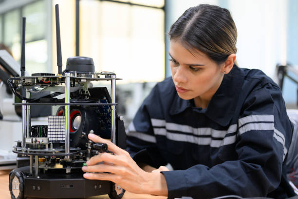 Female technician engineer using laptop checking automatic robotic machine Female technician engineer using laptop checking and operating automatic robotic machine at industrial factory, Worker working with robotic system in factory Master’s Degree in Engineering Management stock pictures, royalty-free photos & images