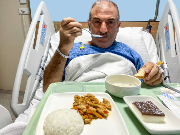 patient mangeant des aliments dans son lit d’hôpital dans sa chambre d’hôpital - 16017 photos et images de collection