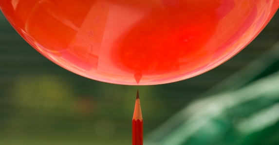 A balloon about to fall on to a pencil